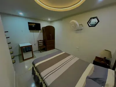 a bedroom with a bed with a fan and a tv at Habitación premium y moderna in La Merced