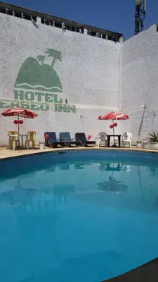 a large swimming pool with chairs and umbrellas at Hotel Perseo Inn in Barranca
