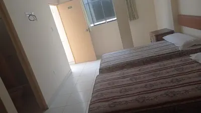a bedroom with a bed with a red blanket on it at Hotel Perseo Inn in Barranca