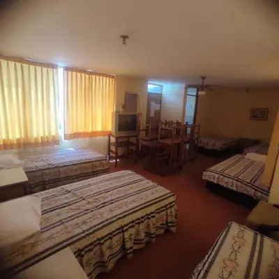 a hotel room with three beds and a television at Hotel Perseo Inn in Barranca