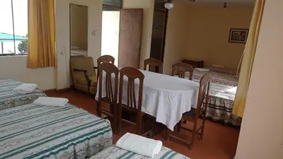 a room with four beds and a table and chairs at Hotel Perseo Inn in Barranca