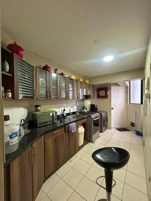 a kitchen with wooden cabinets and a stool in it at Comfort and family exclusivity in Lima