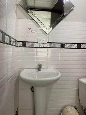a white bathroom with a sink and a mirror at Hostal El Mariscal in Urubamba