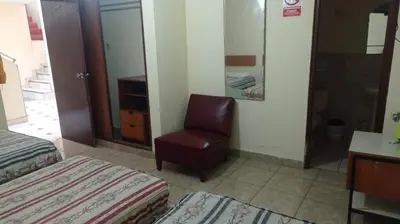 a room with a bedroom with a chair and a mirror at Hotel Perseo Inn in Barranca