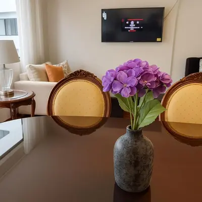 a vase with purple flowers on a table in a living room at Bello departamento en el corazón de Miraflores in Lima