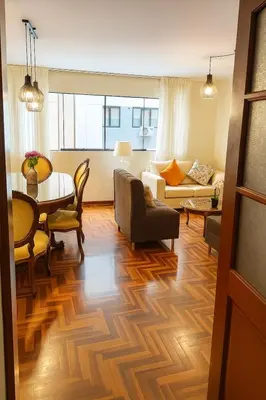 a living room with a table and a couch at Bello departamento en el corazón de Miraflores in Lima