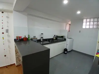 a kitchen with white walls and a black counter top at la casa de Alejandra in Cusco