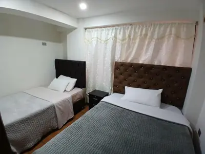 a bedroom with two beds and a window at la casa de Alejandra in Cusco