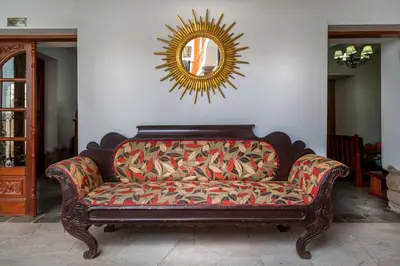a couch sitting in a living room with a mirror at Illa Hotel in Cusco