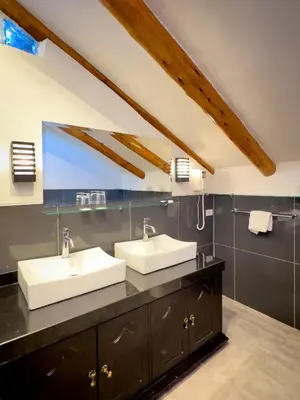 a bathroom with two sinks and a mirror at Illa Hotel in Cusco
