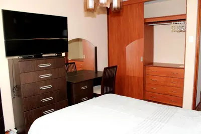 a bedroom with a bed and a desk and a television at Great Location near to everything! in Lima