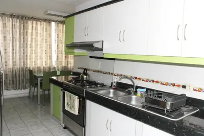 a kitchen with white cabinets and a sink and a stove at Great Location near to everything! in Lima