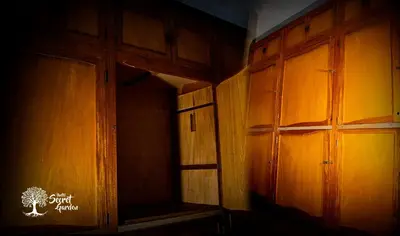 an empty room with wooden cabinets and a window at Taytacha House in Cusco