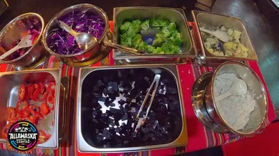 a tray with four trays of different food items at Allawaska Hostel & Camping in Laguna Huacachina