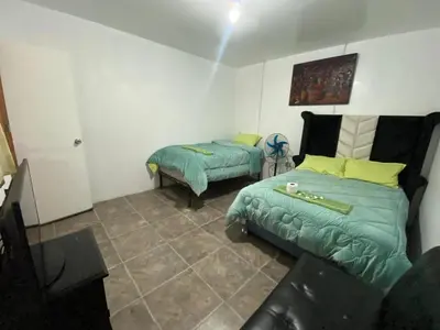 a bedroom with two beds and a couch in it at Allawaska Hostel & Camping in Laguna Huacachina