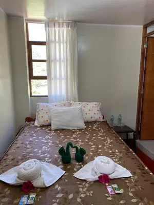 a bedroom with a bed with towels and shoes on it at Eco Lodge Elegant Qollpawasi in Colcapampa