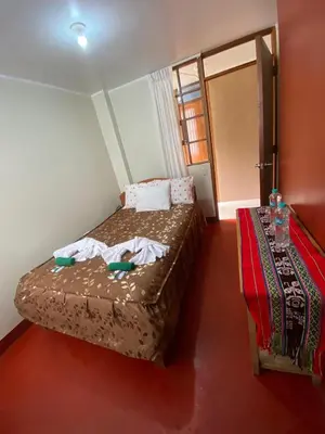 a small bedroom with a bed with towels on it at Eco Lodge Elegant Qollpawasi in Colcapampa