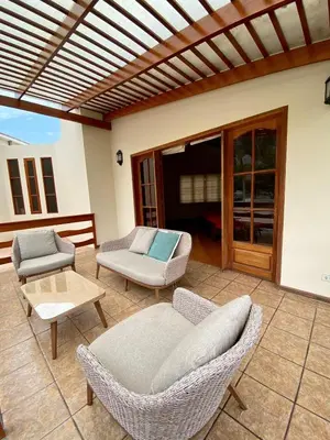 a patio with two chairs and a couch and a table at Casa Vaí Cieneguilla with a pool in Cieneguilla