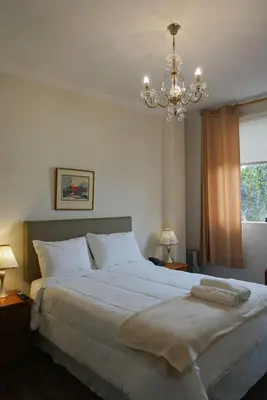 a bedroom with a large bed with a chandelier at Kontiki Miraflores in Lima