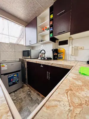 a kitchen with brown cabinets and a counter top at La CASITA in Cusco