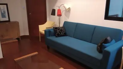 a living room with a blue couch and a table at Travel & Home Place in Lima