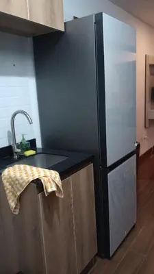 a kitchen with a black refrigerator and a sink at Travel & Home Place in Lima