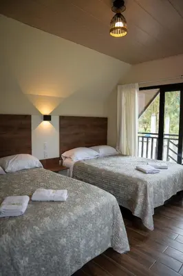 a hotel room with two beds with towels on them at Prana Cabins Oxapampa in Oxapampa
