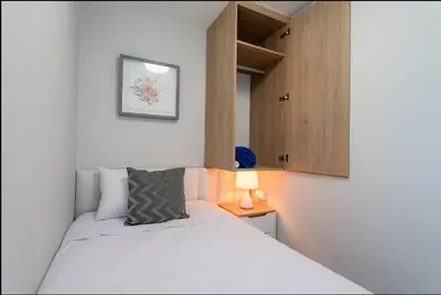 a small bedroom with a bed and a cabinet at DivarAparts#1 in Lima