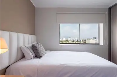 a white bed in a room with a window at DivarAparts#1 in Lima