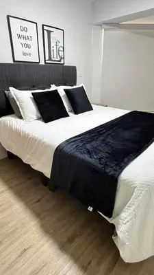 a bedroom with a large bed with black and white pillows at Miraflores Deluxe in Lima