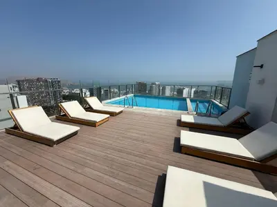 a rooftop deck with lounge chairs and a swimming pool at New apartment in Barranco in Lima