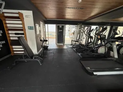 a gym with a row of treadmills and machines at New apartment in Barranco in Lima