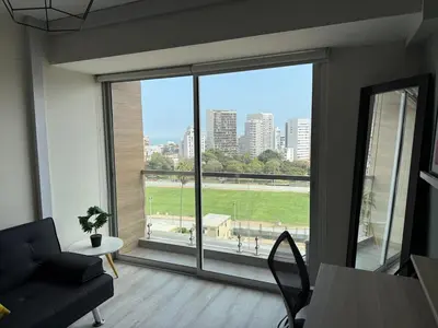 a living room with a large window with a view of a city at BR1 Barranco Exclusive Department in Lima