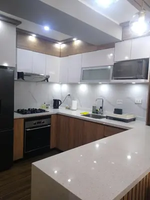 a kitchen with white cabinets and a black refrigerator at Apartamento 3D de estreno muy céntrico in Lima