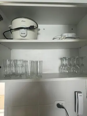a kitchen shelf with glasses and a pot on it at Beautiful apartment with an ocean view in San Bartolo
