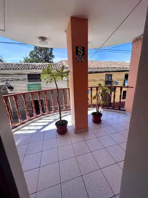 a building with two potted plants in a courtyard at Hs San Cristobal in Ayacucho