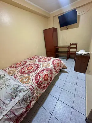 a bedroom with a bed and a table and chairs at Hs San Cristobal in Ayacucho
