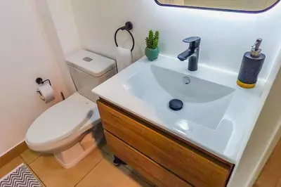 a bathroom with a white sink and a toilet at Cozy apartment in Barranco in Lima