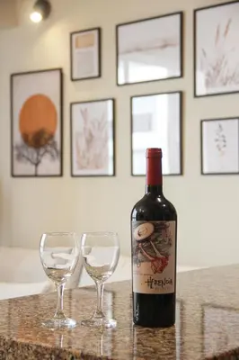 a bottle of wine sitting next to two wine glasses at Cozy apartment in Barranco in Lima