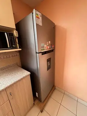 a stainless steel refrigerator in a small kitchen at Departamento in Lima