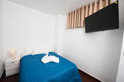 a bedroom with a blue bed and a flat screen tv at Carmen's House in Cusco