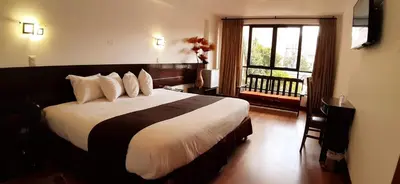 a bedroom with a large bed and a window at Illas Inn in Cusco