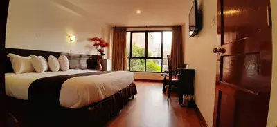 a bedroom with a large bed and a window at Illas Inn in Cusco