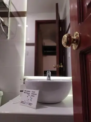 a bathroom with a white sink and a mirror at Illas Inn in Cusco