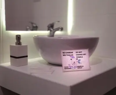 a bathroom sink with a sign on top of it at Illas Inn in Cusco