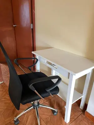 a white desk with a black chair next to it at Departamento amplio y cómodo a 15 minutos del aeropuerto in Lima