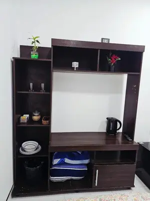 a brown book shelf with plates and pans at Familiar Premium Twin Chanchamayo in La Merced