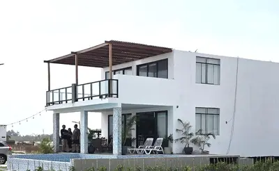 a white house with people standing in front of it at SKY HOUSE con vista al mar in Chincha Baja
