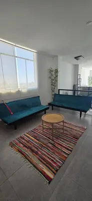 a room with two beds and a table and a rug at SKY HOUSE con vista al mar in Chincha Baja