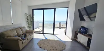 a small child laying on a couch in a living room at SKY HOUSE con vista al mar in Chincha Baja
